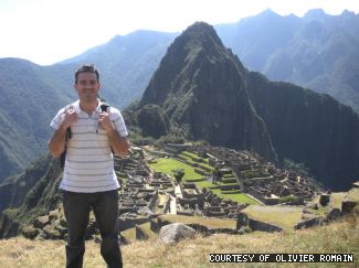 Olivier Romain poses in front of Machu Picchu while traveling through Peru.